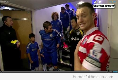 Clint Hill, capitán del QPR, hace de jodefotos a un cámara de tv en Stamford Bridge