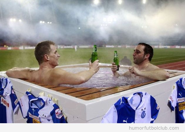 Dos aficionados del Grasshopper Zurich ven el partido en directo en un jacuzzy coon cerveza