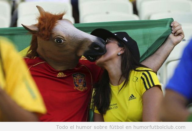 Foto bizarra, una chica besa a un chico con camiseta de España y cabeza de caballo en la Copa Confederaciones