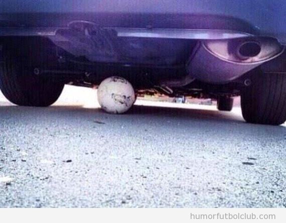 Foto balón fútbol debajo coche