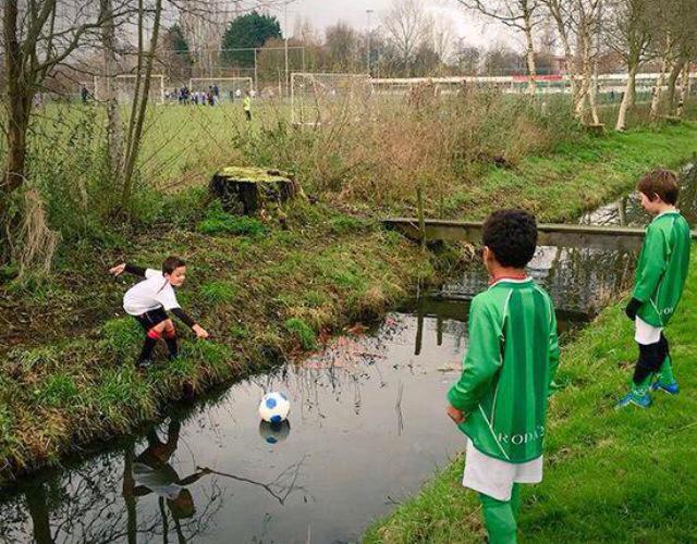 Foto graciosa niños , jugando a fútbol, pelota en el río