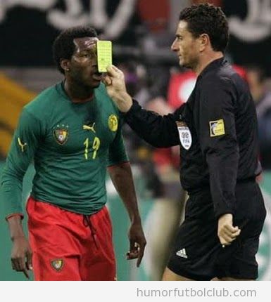Árbitro pone la tarjeta amarilla en la cara del futbolista
