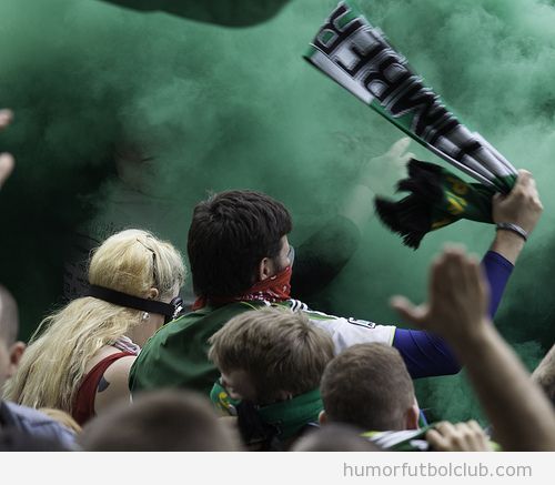 Aficionados en medio de un tifo con bengalas de humo verde