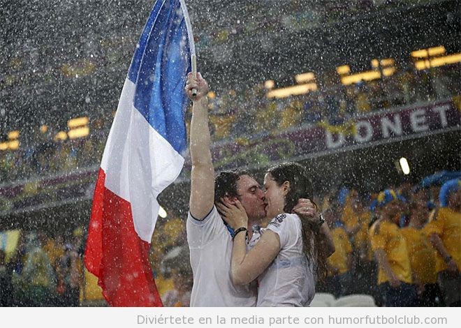 Aficionados de Francia se dan un beso bajo la lluvia en el Francia Ucrania