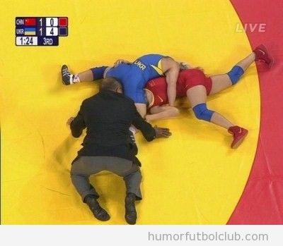 Foto divertida de un árbitro de lucha grecorromana metiendo la cabeza entre las piernas de un luchador en los Juegos Olímpicos 2012