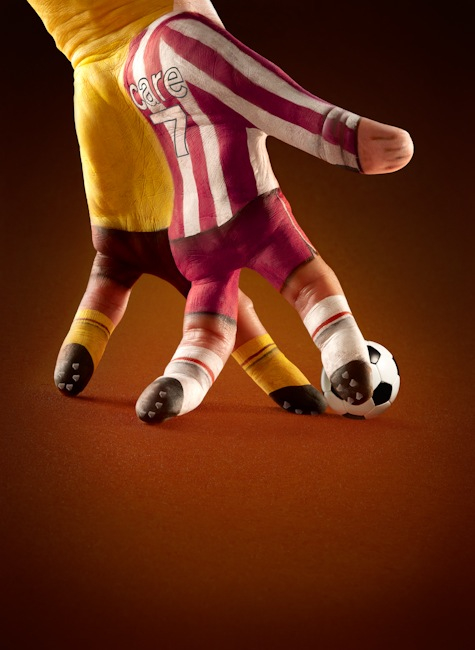 Foto bonita de una mano pintada con dos jugadores de fútbol