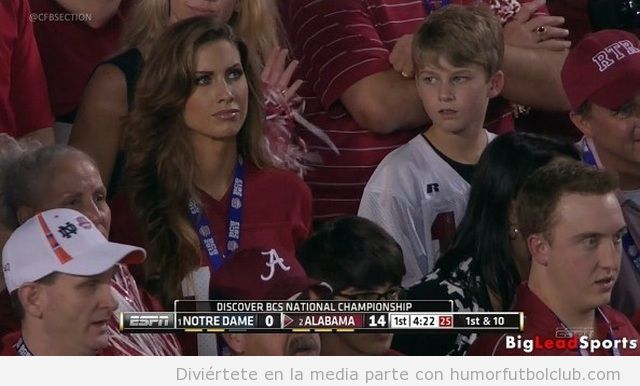 Foto graciosa de un niño mirando a una chica guapa en un partido de fútbol americano