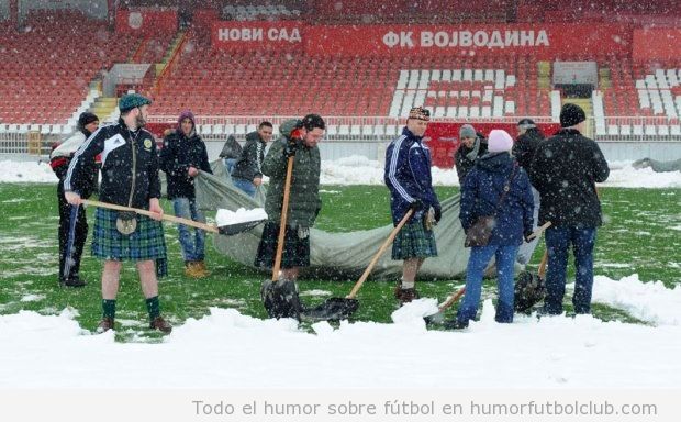 Aficionados de Escocia ayudando a los serbios a quitar nieve del campo
