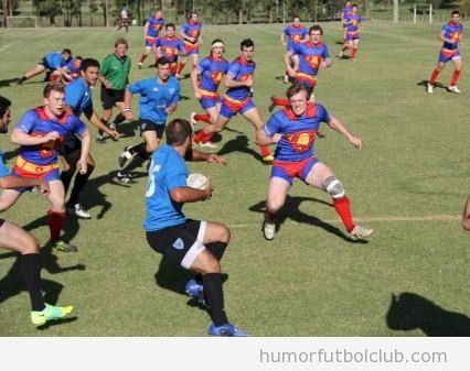 Foto graciosa de un partido de rugby con un equipo vestido de superman