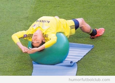 Imagen chistosa de jugadores japoneses estirando con balón de pilates