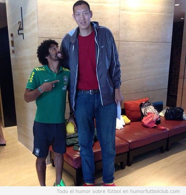 Foto graciosa del defensa de Brasil Dayne con el jugador de basket chino Sun Ming Ming