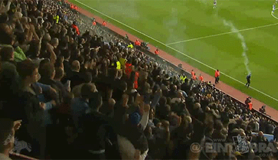 Gif animado, aficionados del Tottenham lanzando una bengala al linier